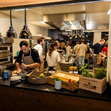 Die Teilnehmer:innen bereiten ihre Gerichte unter viel Netzwerken und viel Freude zu