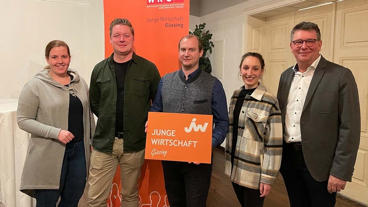 Gruppenbild von fünf Menschen, die ein JW-Schild halten