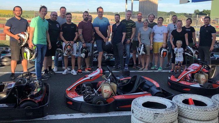 Gruppe Menschen vor Kart-Race-Autos