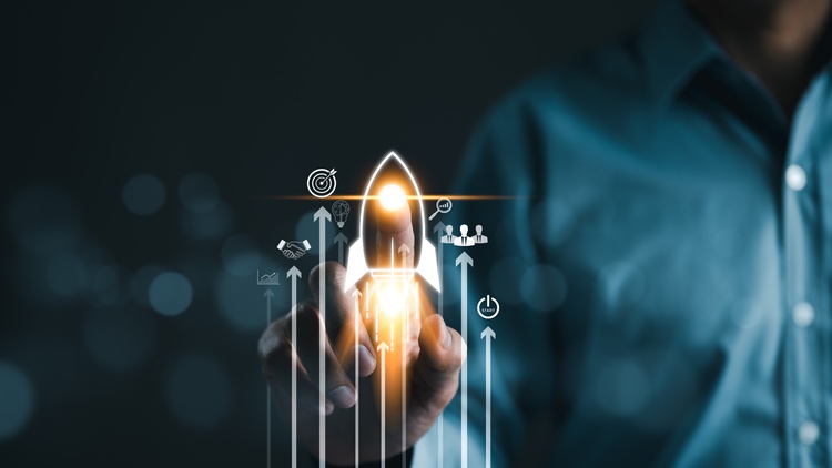 Im Vordergrund sind verschiedene Symbole wie eine startende Rakete, eine Zielscheibe, sich schüttelnde Hände, eine Lupe, die Umrisse von Personen. Dahinter ist eine Person, die mit dem rechten Zeigefinger die Rakete berührt